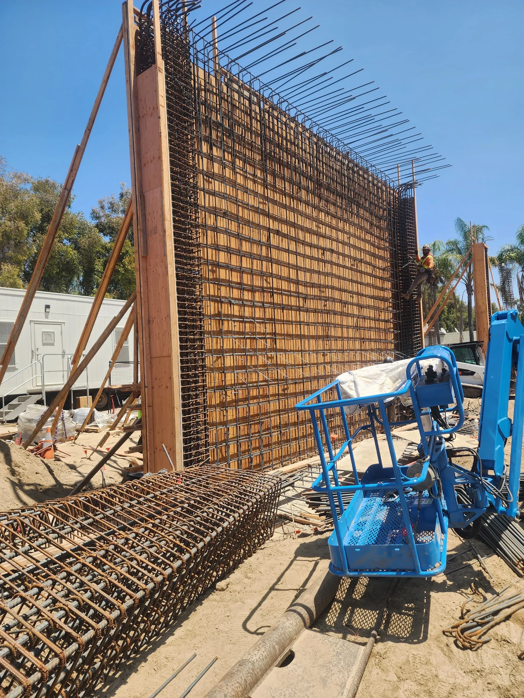 Podium deck retaining wall rebar installation for structural concrete support